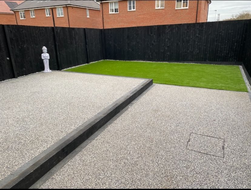 Resin bound surface with charcoal kerb edge and artificial grass installed by Hedgeway Paving