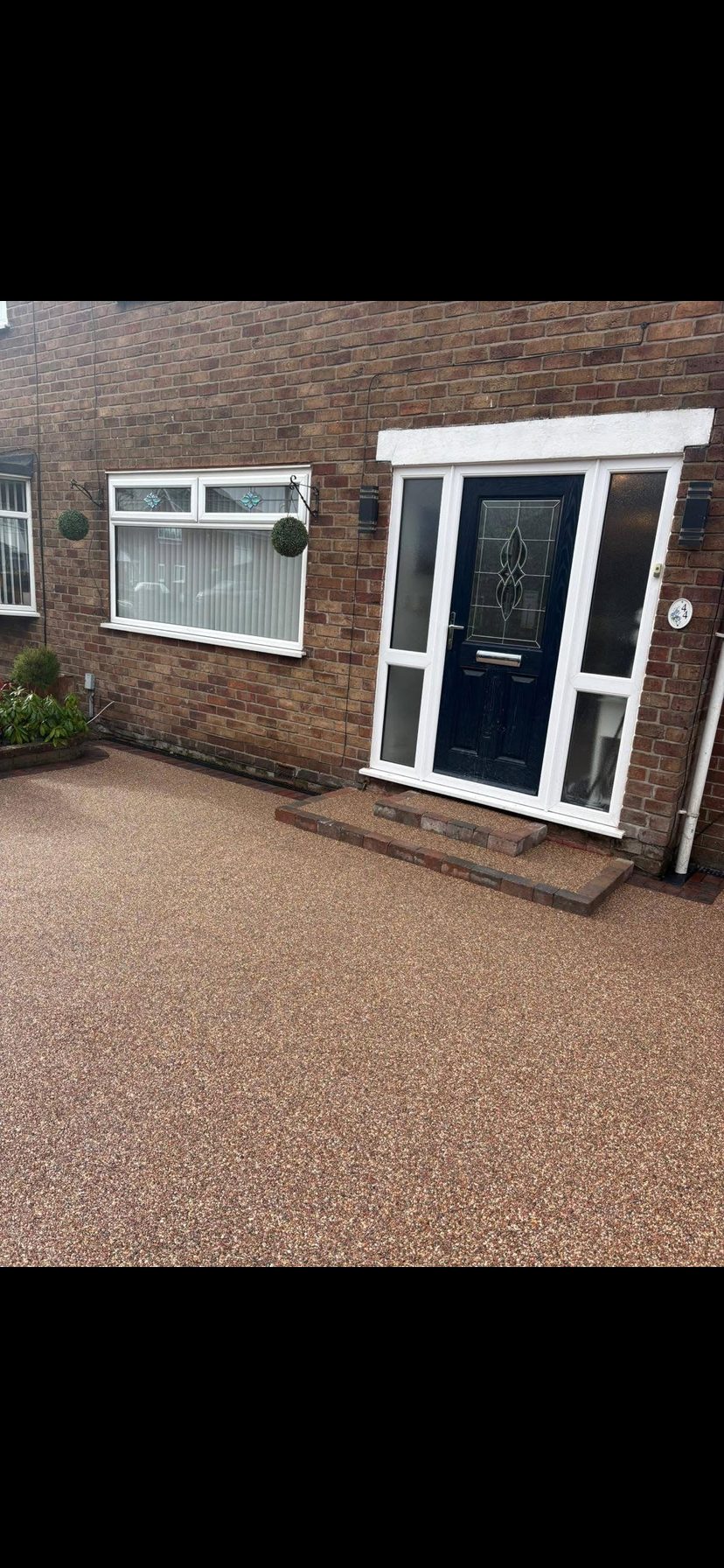 Finished resin bound driveway leading to a modern porch entrance by Hedgeway Paving